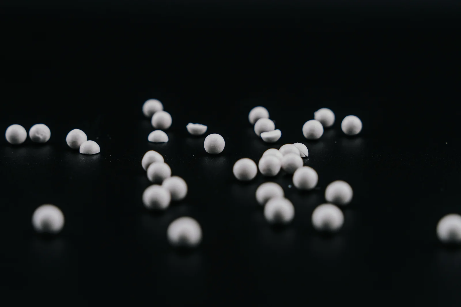 A close view of white lyophilized beads, showing their physical surface and rounded shapes.