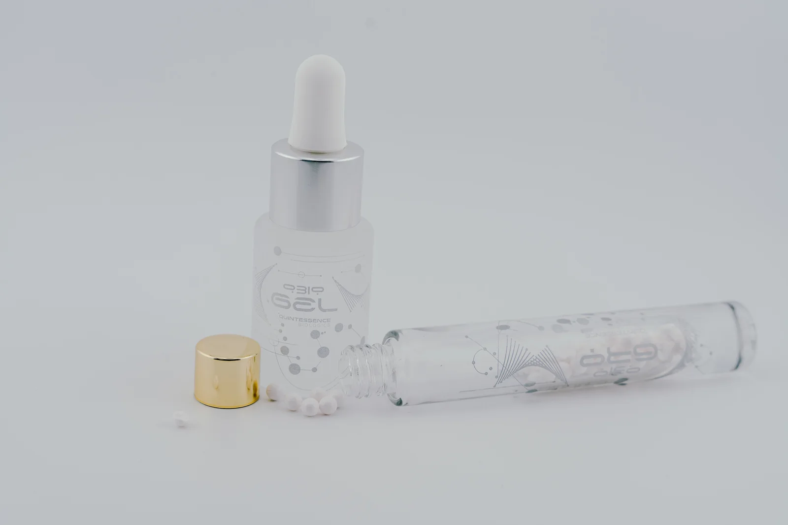An open QBio Gro vial with white beads beside a silver-collar QBio Gel bottle.
